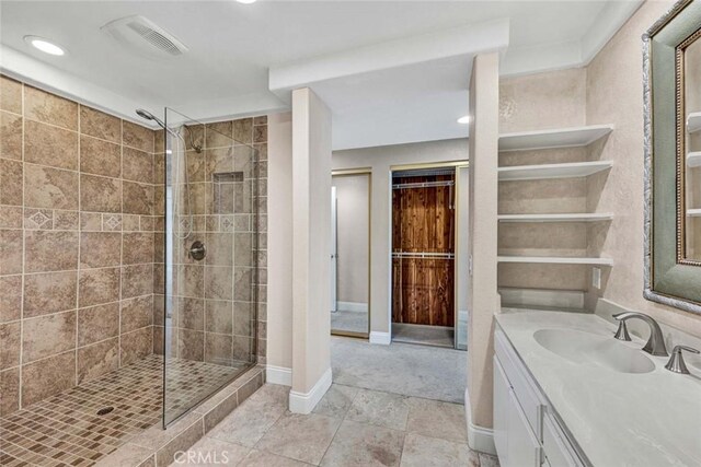 bathroom featuring a tile shower, vanity, recessed lighting, and baseboards