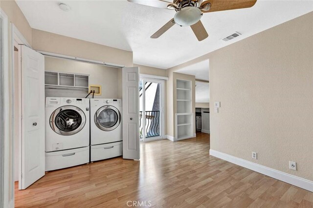 laundry room with washing machine and clothes dryer, a ceiling fan, light wood finished floors, and baseboards