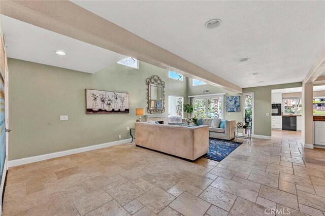 living area with stone tile floors, baseboards, and recessed lighting