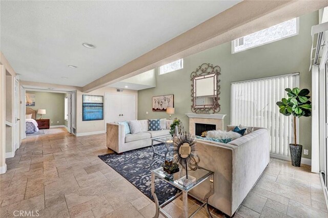 living room featuring stone tile floors, baseboards, and a high ceiling