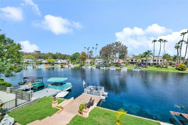 dock area featuring a water view and a lawn