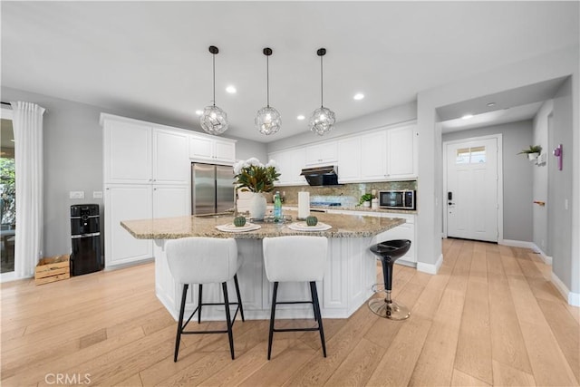 228 Wicker, Irvine, CA 92618 - kitchen featuring appliances with stainless steel finishes, decorative backsplash, white cabinetry, light stone counters, and recessed lighting