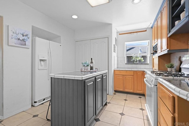 4625 68th St, La Mesa, CA 91942 - kitchen featuring white appliances, tile countertops, light tile patterned floors, tasteful backsplash, and a kitchen island