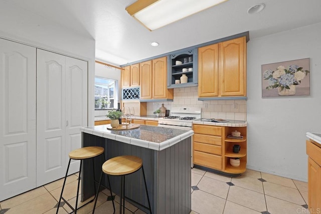 4625 68th St, La Mesa, CA 91942 - kitchen with white gas range, open shelves, backsplash, tile counters, and a kitchen breakfast bar