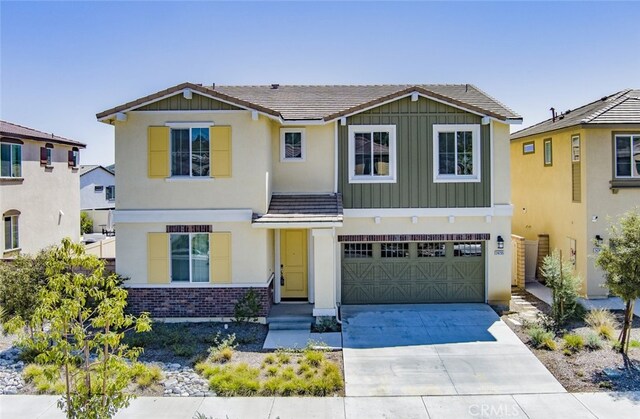 24295 Insignia Dr, Menifee, CA 92584 - view of front of property with brick siding, driveway, a garage, board and batten siding, and stucco siding