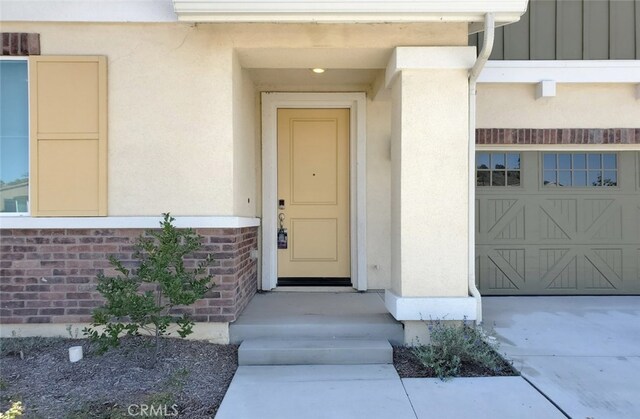 24295 Insignia Dr, Menifee, CA 92584 - view of exterior entry with stucco siding and a garage