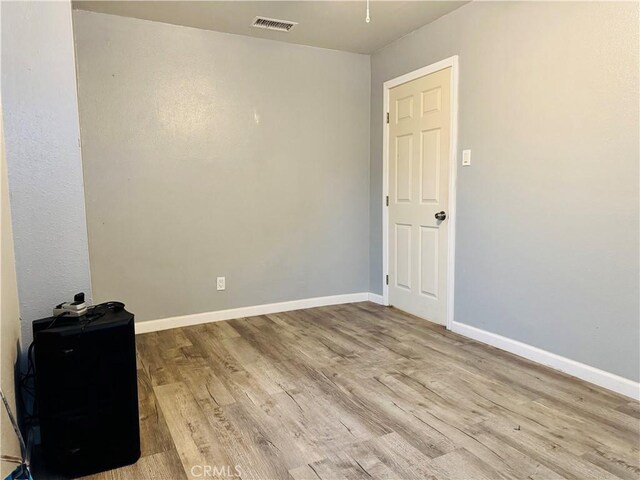 spare room with wood finished floors and baseboards