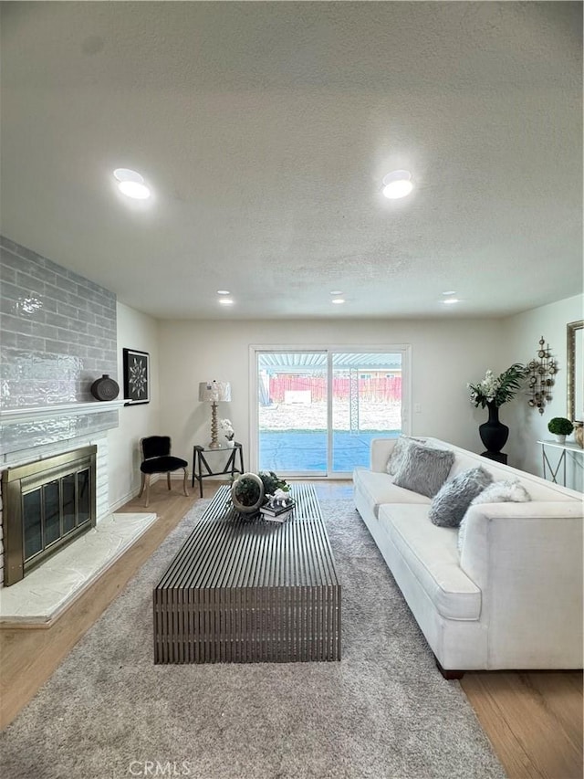 2126 S Fern Ave, Ontario, CA 91762 - living area featuring wood finished floors, a fireplace, a textured ceiling, and recessed lighting