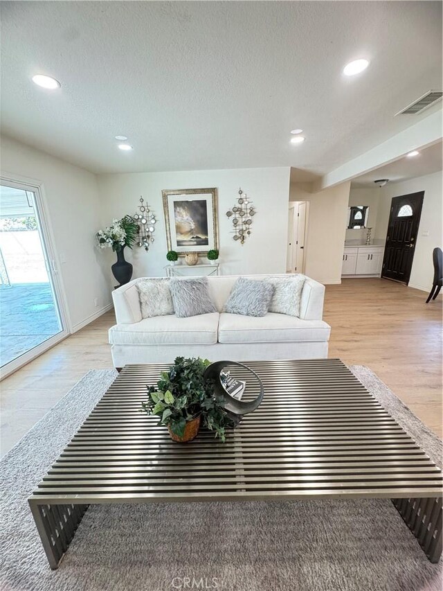 2126 S Fern Ave, Ontario, CA 91762 - living area with light wood-style floors, recessed lighting, and a textured ceiling