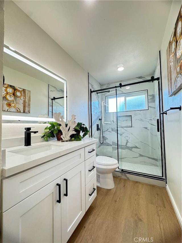 2126 S Fern Ave, Ontario, CA 91762 - full bathroom with wood finished floors, toilet, a marble finish shower, and vanity