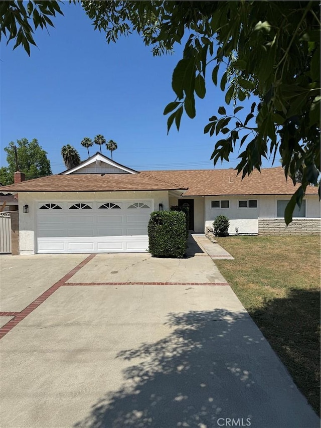 2126 S Fern Ave, Ontario, CA 91762 - ranch-style house featuring stucco siding, driveway, an attached garage, and a front lawn