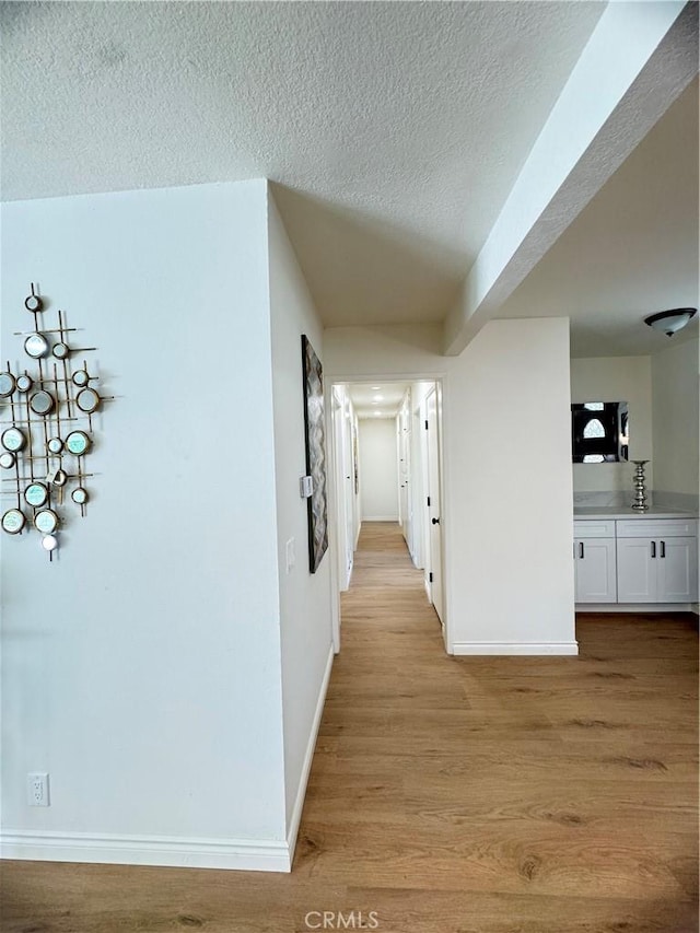 2126 S Fern Ave, Ontario, CA 91762 - hallway with a textured ceiling, baseboards, and light wood-type flooring
