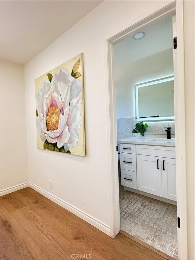 2126 S Fern Ave, Ontario, CA 91762 - hallway with light wood-type flooring, a sink, and baseboards