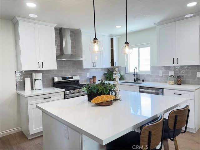 2126 S Fern Ave, Ontario, CA 91762 - kitchen featuring wall chimney exhaust hood, a sink, appliances with stainless steel finishes, light countertops, and light wood-type flooring