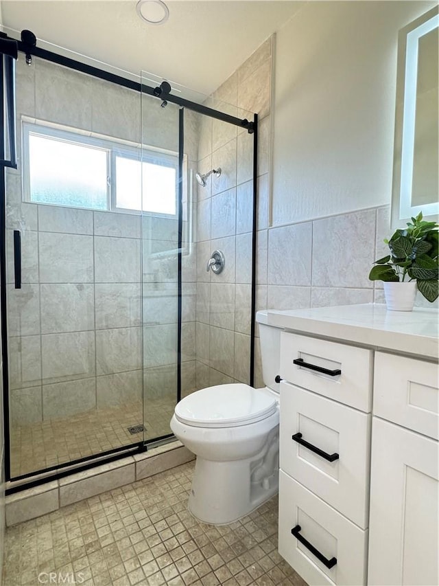 2126 S Fern Ave, Ontario, CA 91762 - full bathroom with tile walls, toilet, a stall shower, vanity, and tile patterned flooring