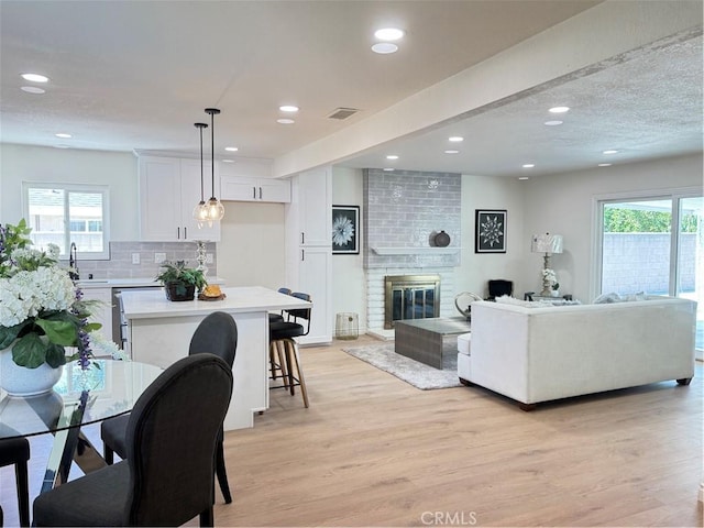 2126 S Fern Ave, Ontario, CA 91762 - living area featuring light wood-style flooring, plenty of natural light, recessed lighting, and a brick fireplace