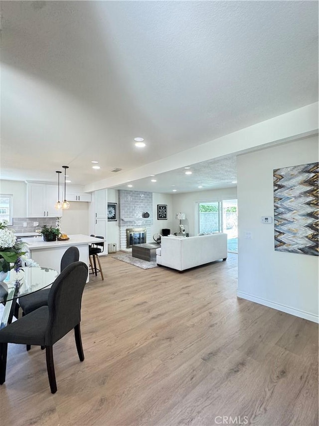 2126 S Fern Ave, Ontario, CA 91762 - living area featuring light wood-style flooring, recessed lighting, a brick fireplace, and baseboards