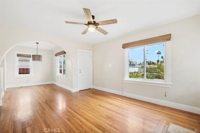 4718 Dawes St, San Diego, CA 92109 - unfurnished living room with arched walkways, light wood-style floors, ceiling fan, and baseboards