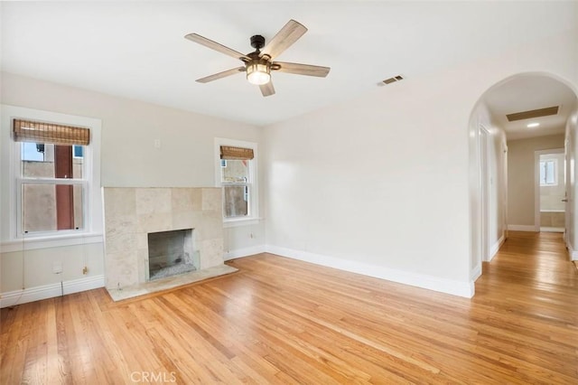 4718 Dawes St, San Diego, CA 92109 - unfurnished living room with arched walkways, light wood-type flooring, a tile fireplace, and baseboards