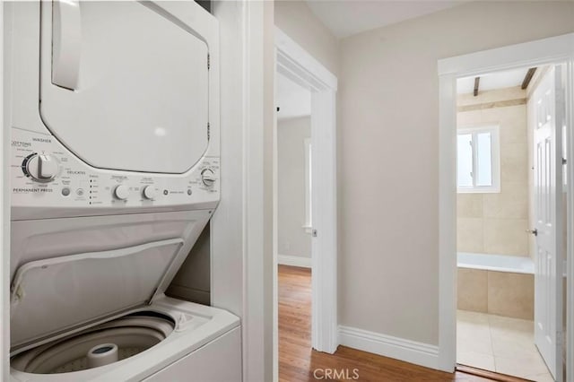 4718 Dawes St, San Diego, CA 92109 - washroom with stacked washer and clothes dryer, wood finished floors, and baseboards