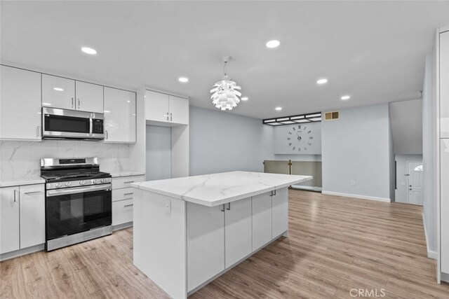 kitchen with stainless steel appliances, white cabinetry, light wood-style floors, recessed lighting, and tasteful backsplash