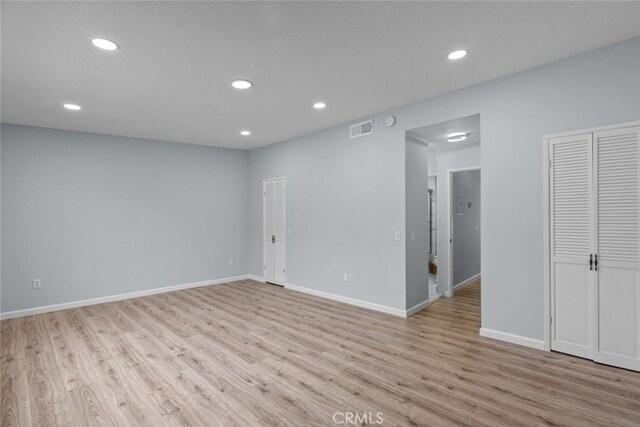 empty room featuring wood finished floors, recessed lighting, and baseboards