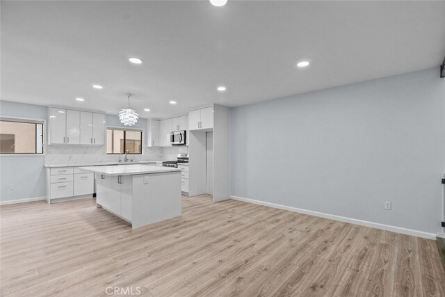kitchen with stainless steel appliances, white cabinetry, recessed lighting, baseboards, and light countertops