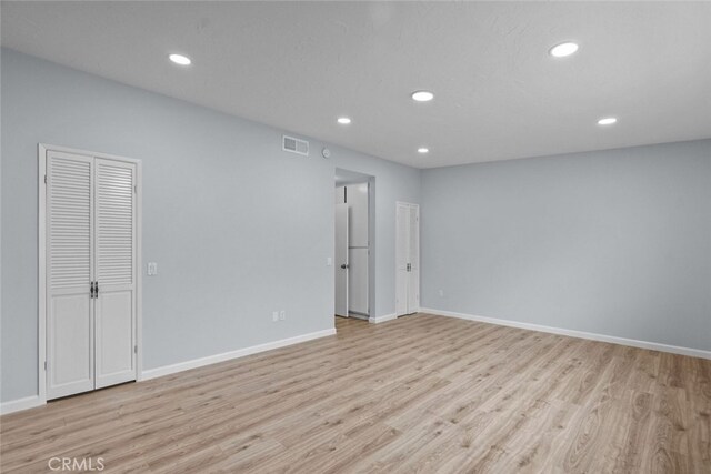 empty room with light wood-style flooring, recessed lighting, and baseboards