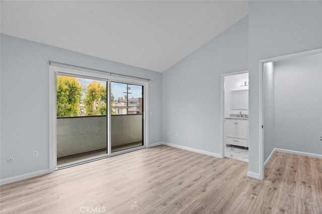 unfurnished bedroom featuring access to exterior, wood finished floors, vaulted ceiling, and baseboards