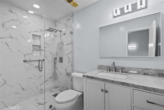bathroom with toilet, a marble finish shower, vanity, and marble finish flooring