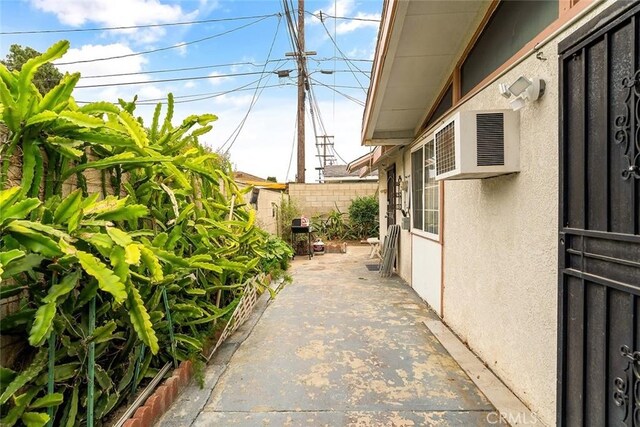 view of side of property featuring fence, a patio area, and stucco siding