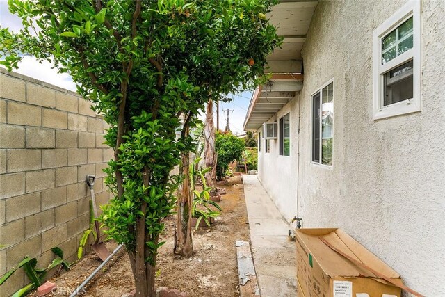 view of property exterior with stucco siding and fence