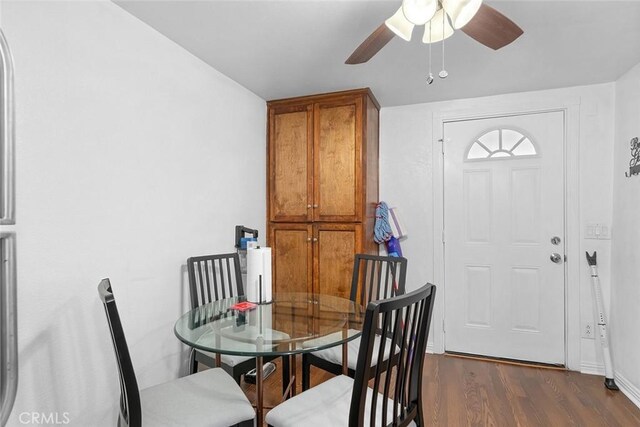 dining room featuring ceiling fan, dark wood-style floors, and baseboards