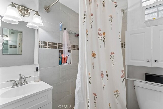 full bathroom featuring vanity, toilet, and curtained shower
