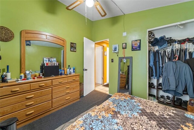 carpeted bedroom featuring a closet, a ceiling fan, and tile patterned flooring