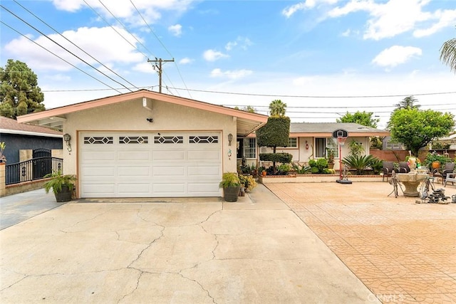 ranch-style house featuring stucco siding, a garage, concrete driveway, and fence