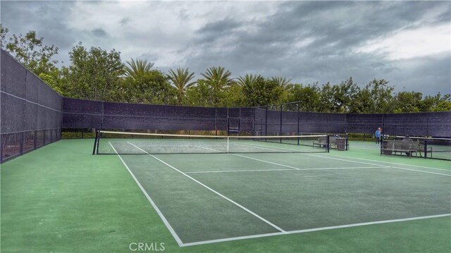 view of tennis court featuring fence