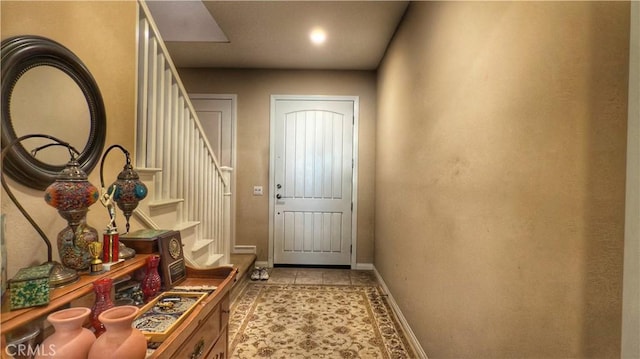doorway with baseboards, stairs, and light tile patterned floors