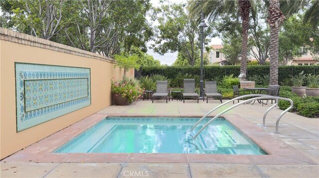view of pool with a patio, a pool, and fence