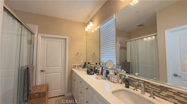bathroom featuring a stall shower and double vanity