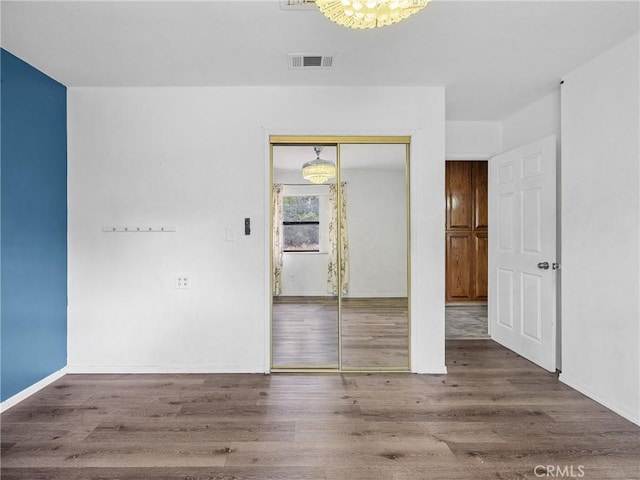 1275 Tamarack Rd, Pinon Hills, CA 92372 - unfurnished bedroom with wood finished floors, a closet, baseboards, and a chandelier