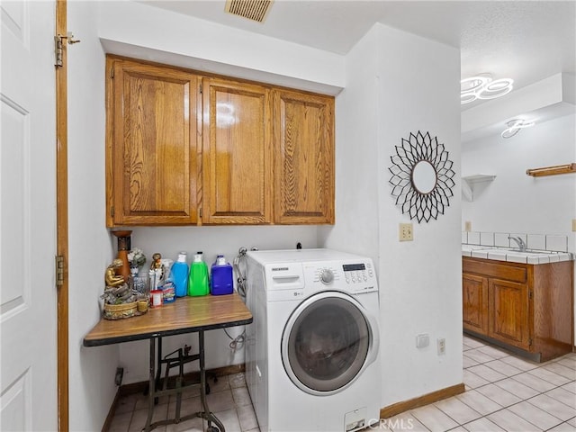 1275 Tamarack Rd, Pinon Hills, CA 92372 - washroom featuring washer / clothes dryer, cabinet space, light tile patterned floors, and baseboards