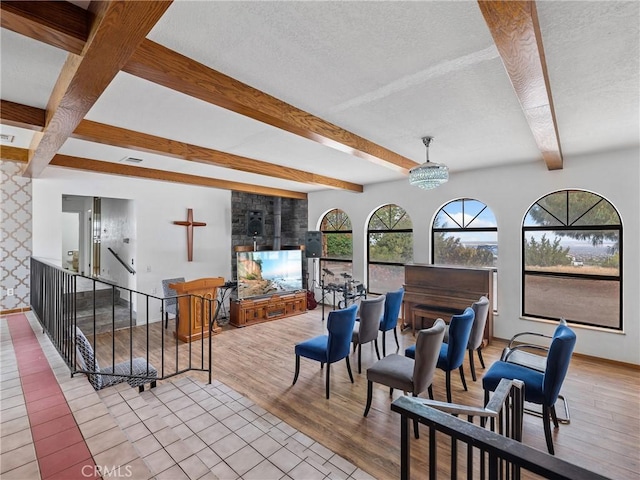 1275 Tamarack Rd, Pinon Hills, CA 92372 - living room with beamed ceiling, baseboards, a textured ceiling, wood finished floors, and a fireplace