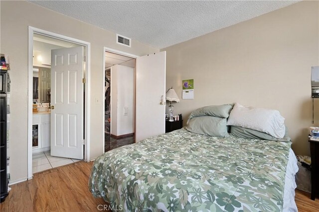 6255 Woodman Ave Unit 103, Van Nuys, CA 91401 - bedroom featuring wood finished floors and a textured ceiling