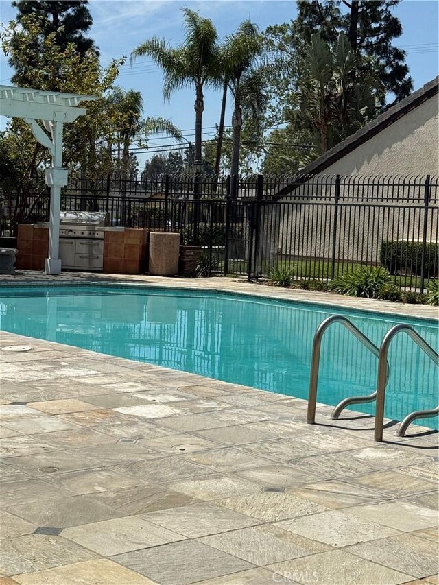 view of swimming pool with fence and a patio area