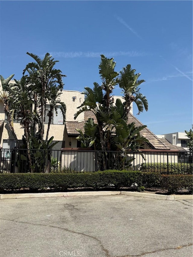 view of side of property with stucco siding and fence