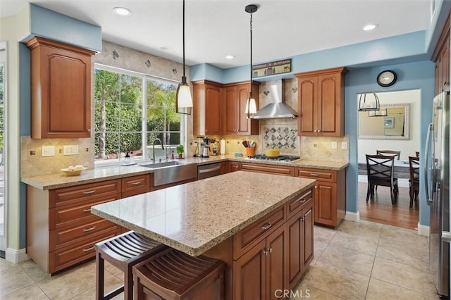 23405 Winslow Pl, Valencia, CA 91354 - kitchen with wall chimney exhaust hood, appliances with stainless steel finishes, light stone counters, a kitchen island, and light tile patterned floors