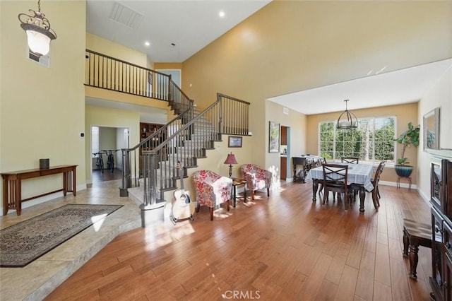 23405 Winslow Pl, Valencia, CA 91354 - living area with wood finished floors, a towering ceiling, stairs, baseboards, and recessed lighting