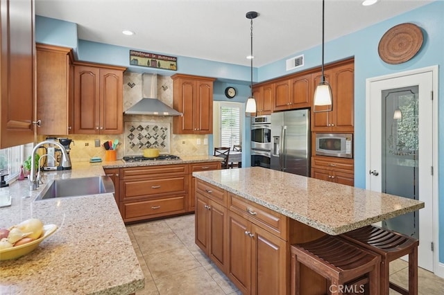 23405 Winslow Pl, Valencia, CA 91354 - kitchen with appliances with stainless steel finishes, wall chimney exhaust hood, backsplash, light stone countertops, and brown cabinetry