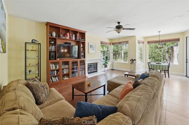 23405 Winslow Pl, Valencia, CA 91354 - living area with ceiling fan, baseboards, and a glass covered fireplace